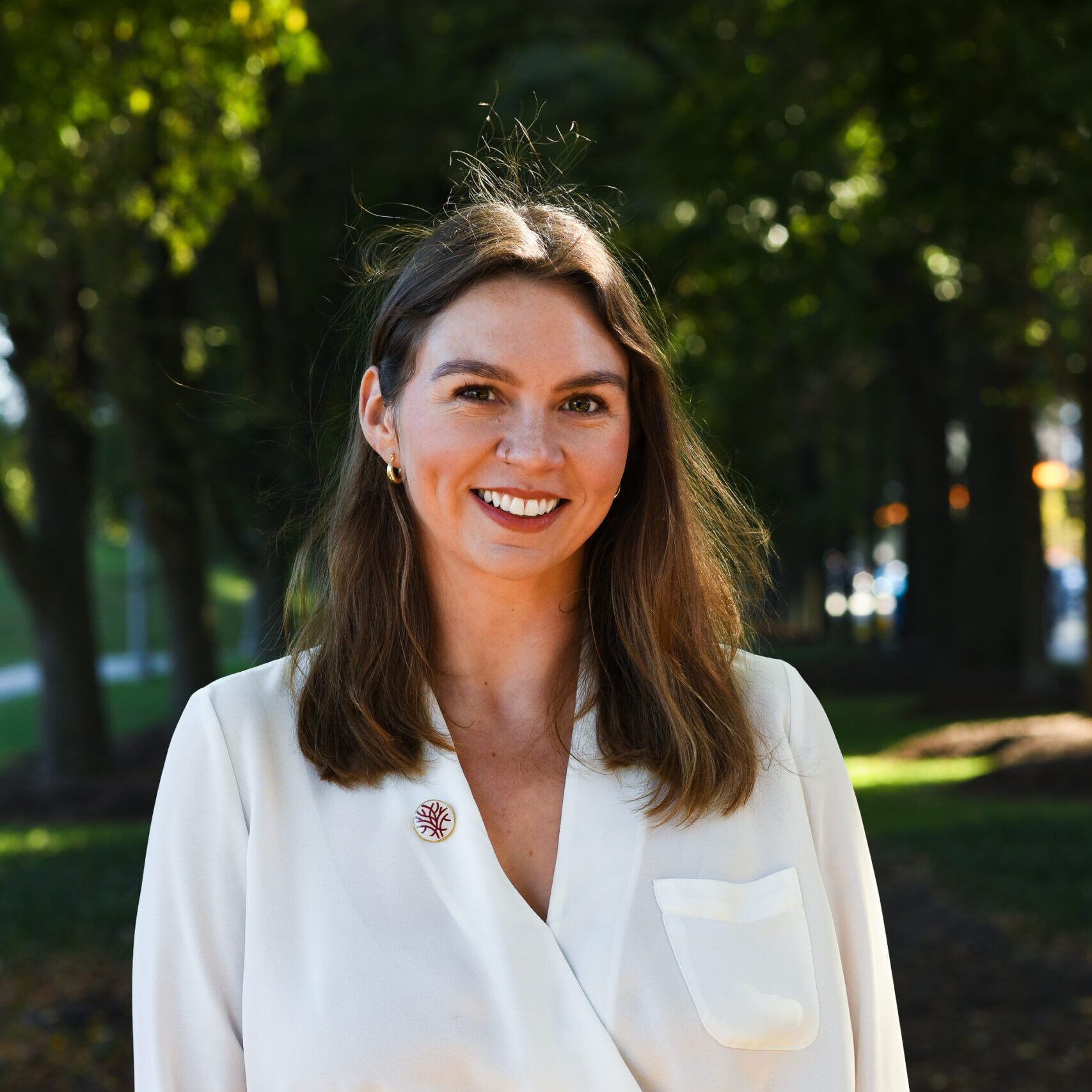 Headshot Openlands Director of Conservation Workforce Katie Fleming with a background of trees