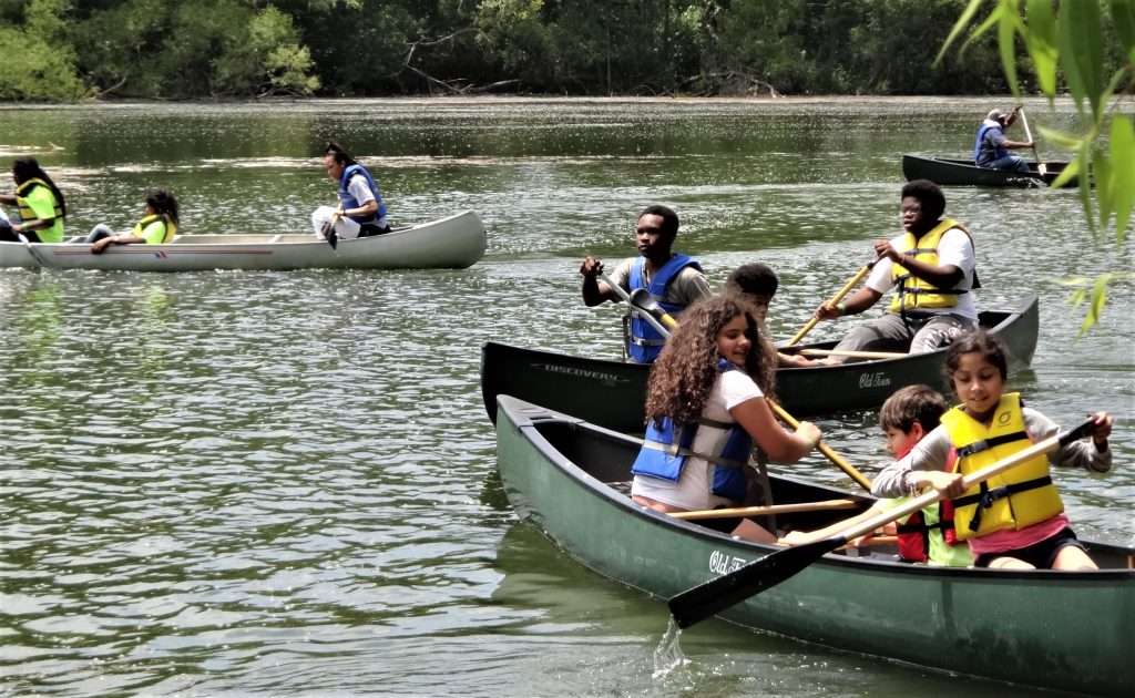 a group of people in kayaks paddling down a river