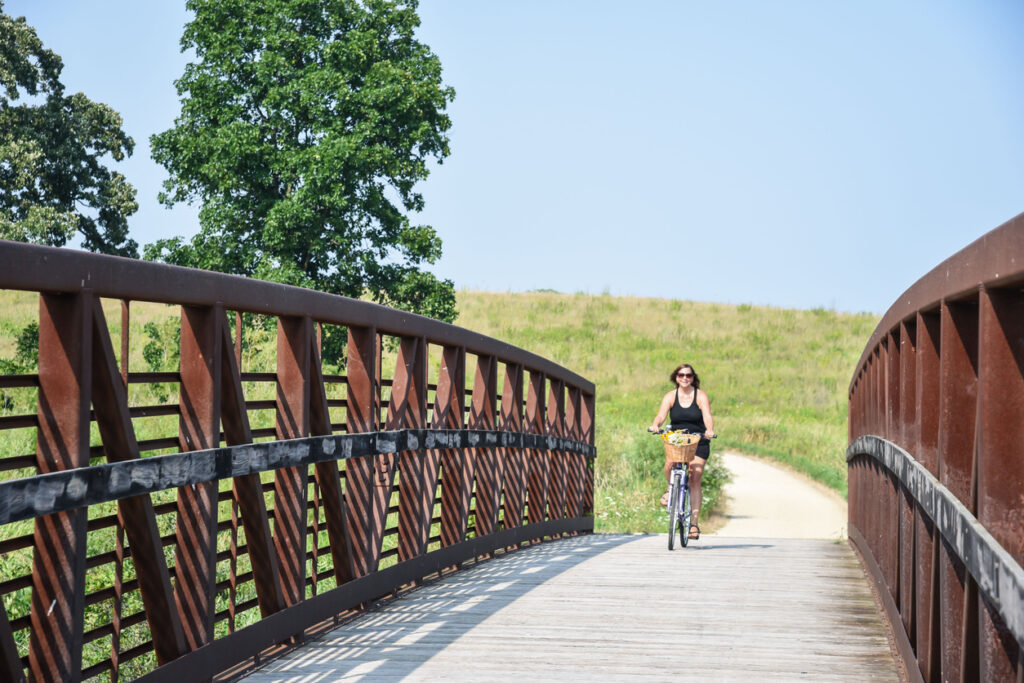 smiling woman riding bicycle on path in Illinois