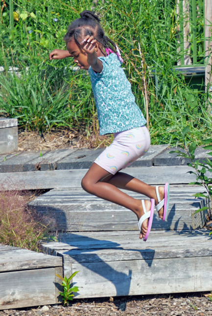 A girl playing in a natural playground setting