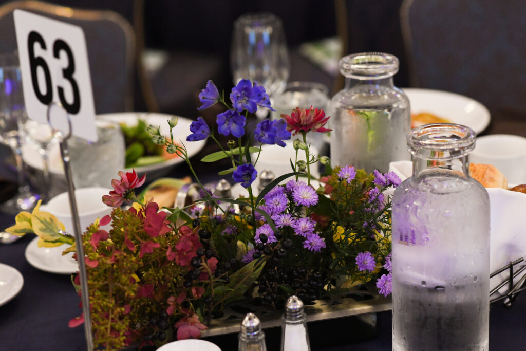 A table with a vase of flowers and a bottle of water, adding a touch of nature and freshness to the room.