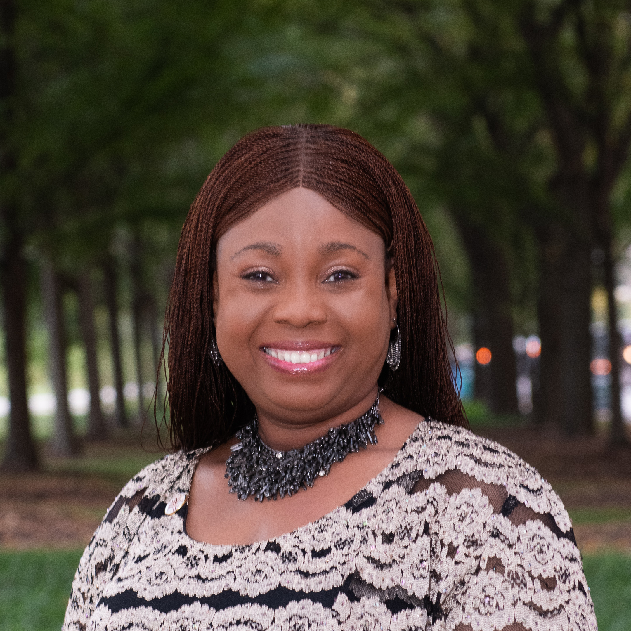 Headshot Openlands Staff Accountant Ochuko Nana with trees in the background