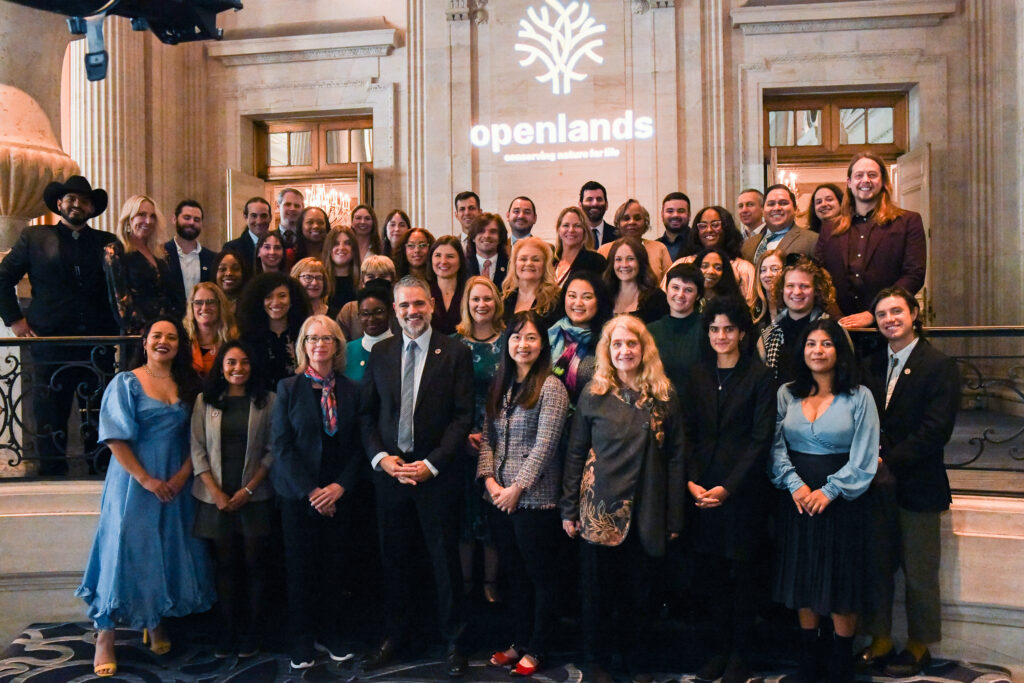 Group photo indoors with "Openlands" logo, formal attire, elegant room with columns.