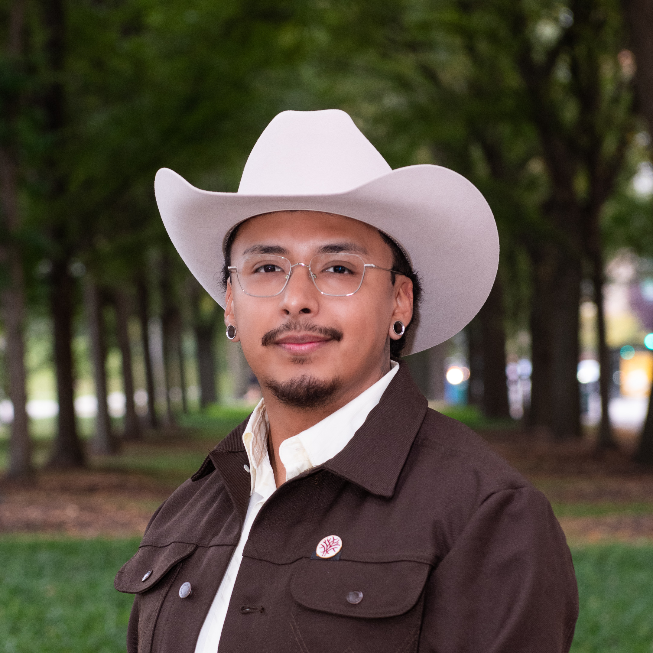 Headshot of Openlands' Forestry Specialist Carlos Ortega with trees in the background