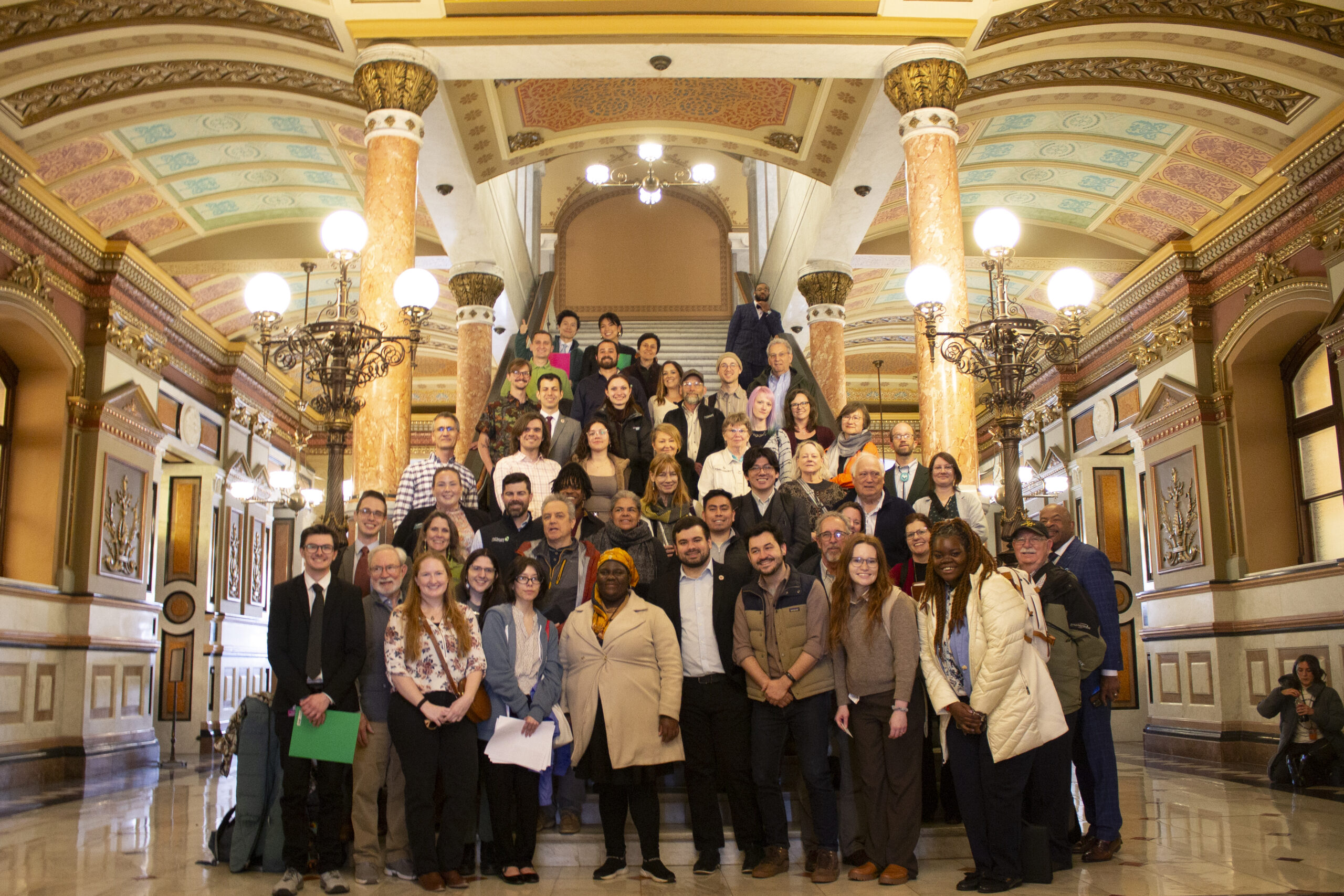 A group of people standing on a capitol staircase.