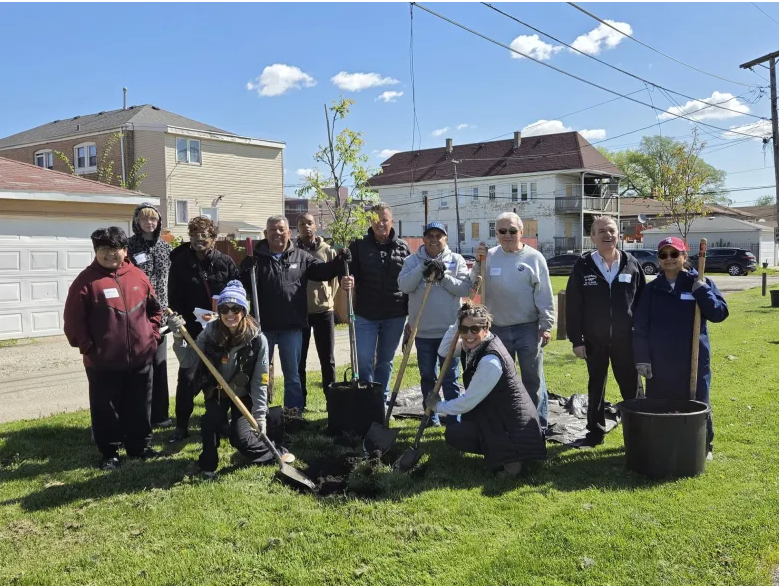 Group posing in front of planted tree in Argo Park