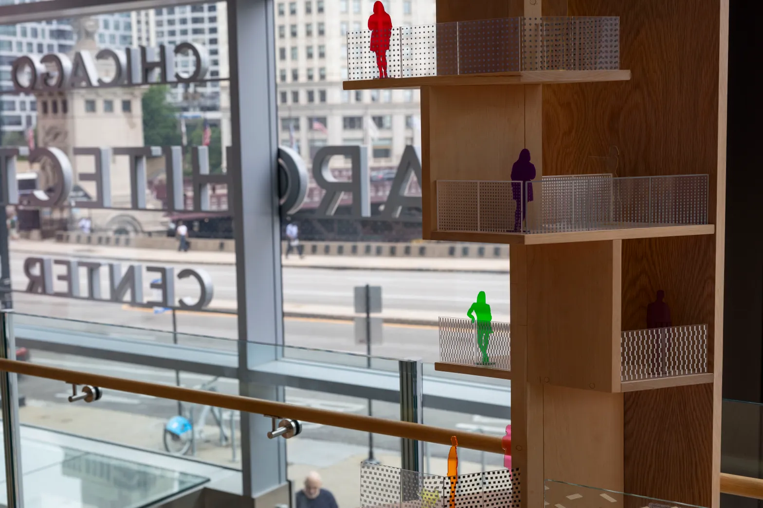 Model of building with people standing on balconies showcasing bird friendly glass