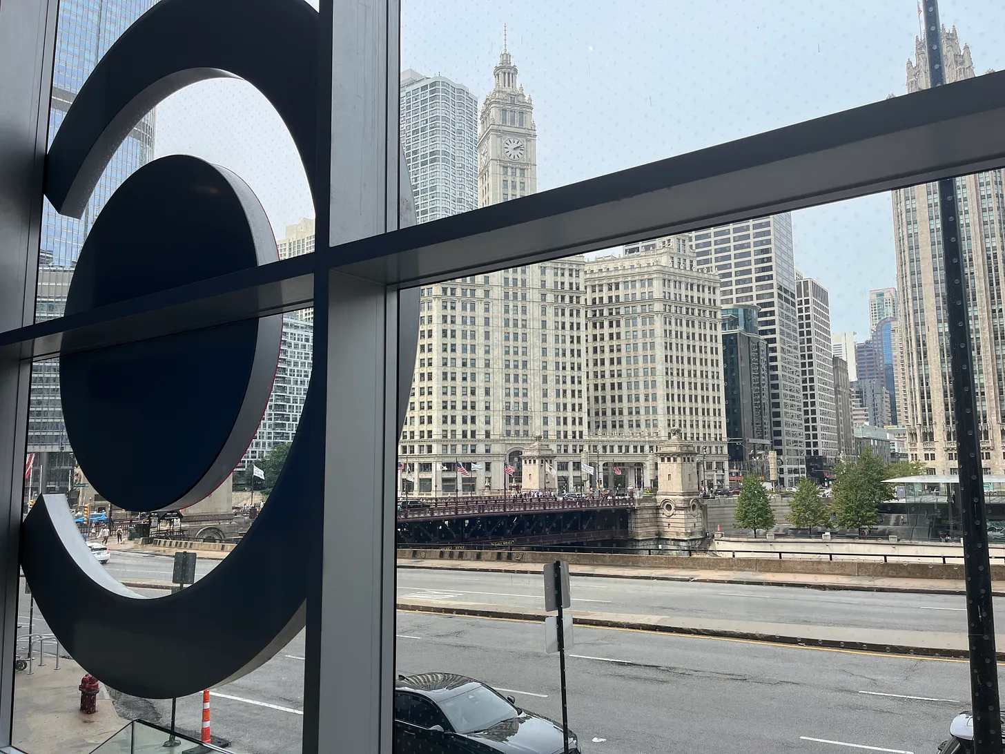 View through window of Chicago Architecture Center onto street with one car.